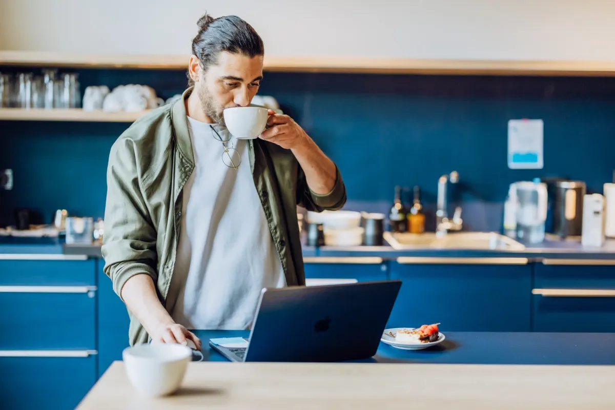 Mann an Kaffeemaschine als Sinnbild für moderne, wartungsfreie Cloud-Infrastruktur