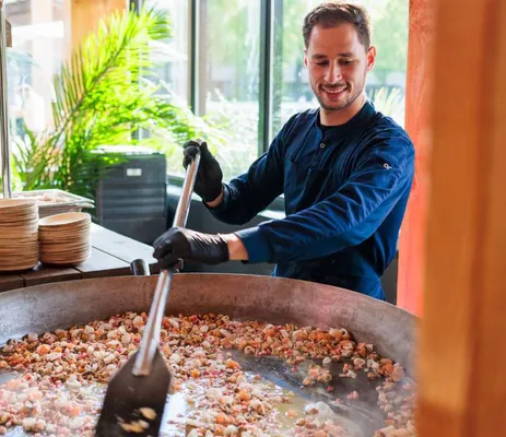 Chef cooking paella fresh on site at Strandzuid